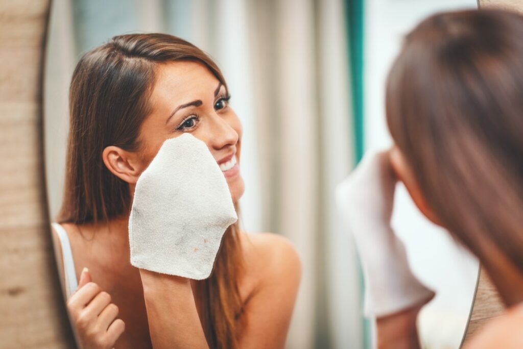 Young woman cleaning her face with facial wipes