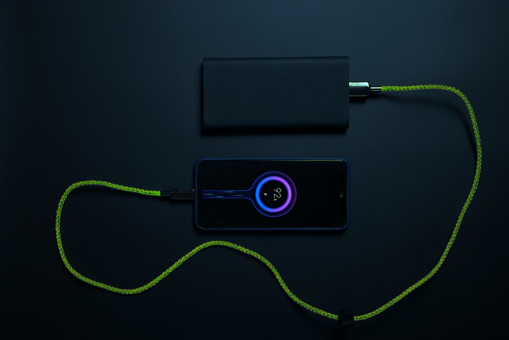 smartphone connected to powerbank on neon charger. High quality photo