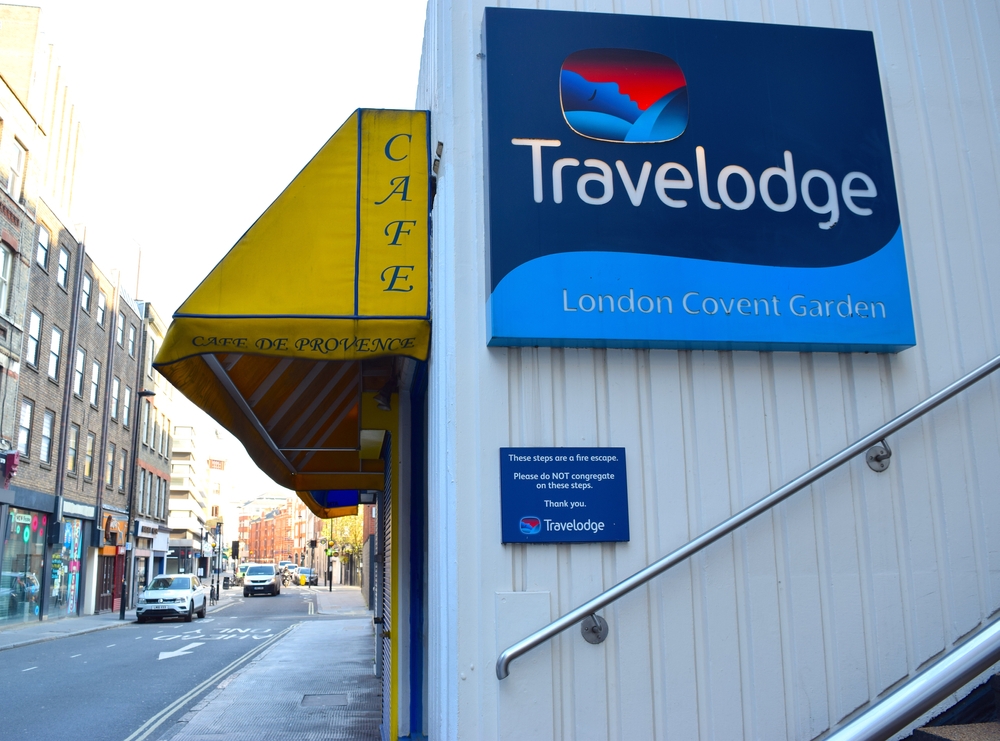 Travelodge building sign on London city centre street. Affordable hotel in London