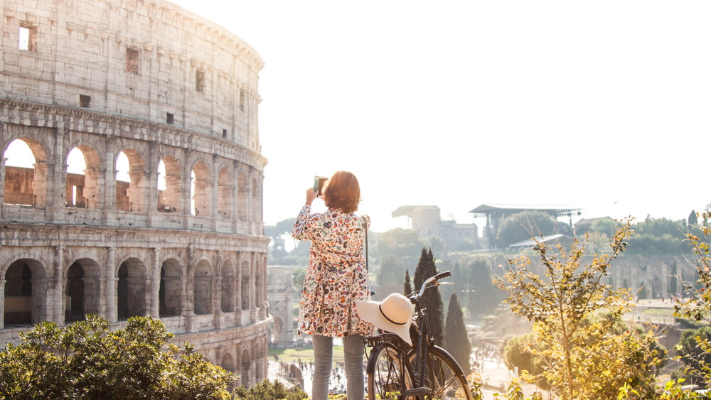 A female tourist taking picture of Rome's ancient building